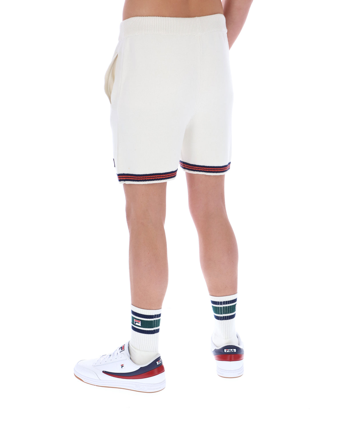 Person wearing white shorts with red and blue trim on a white background