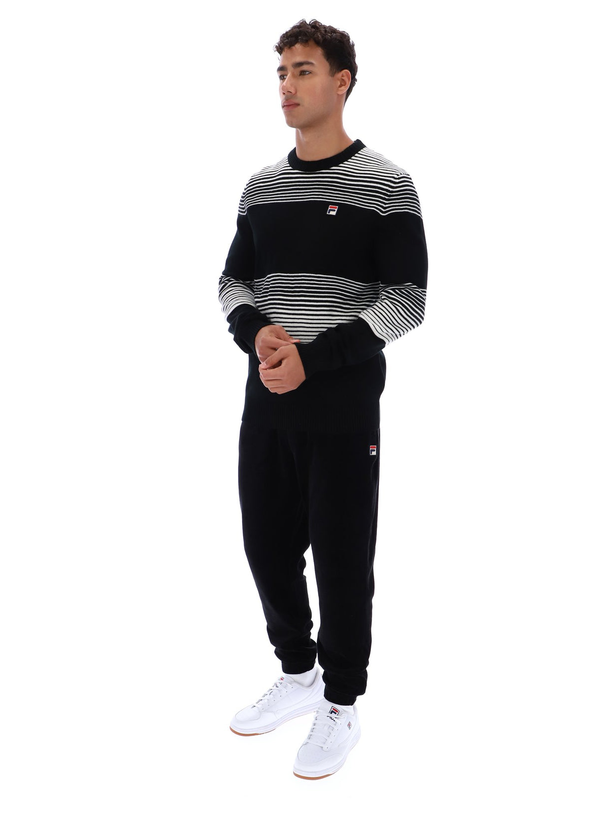 Displays a model wearing the Black 'FILA' branded Connor Striped Knit Crew Neck