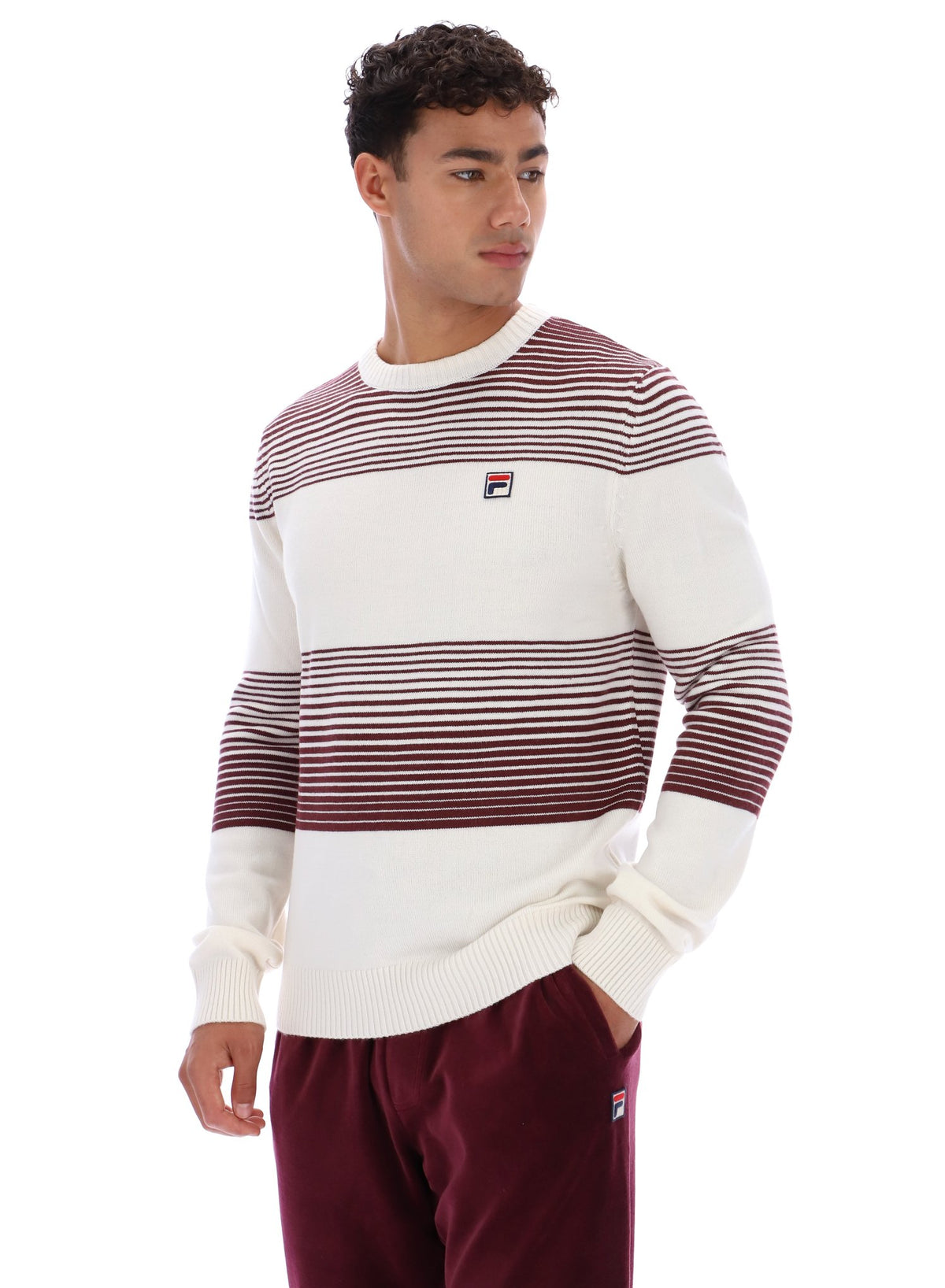 Man wearing a white and red striped sweater with FILA logo on a white background