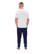 Man wearing a white t-shirt and navy pants on a white background