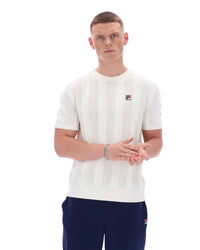 Man wearing a white textured sweater with a small logo on a white background