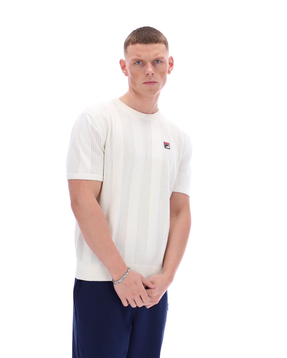 Man wearing a white t-shirt with a small logo on a white background