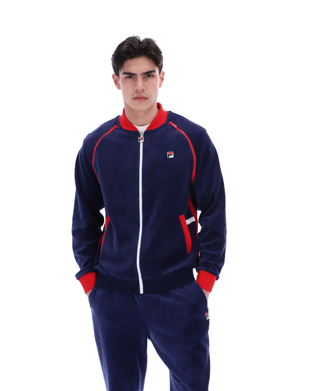 Man wearing a navy tracksuit with red accents on a white background
