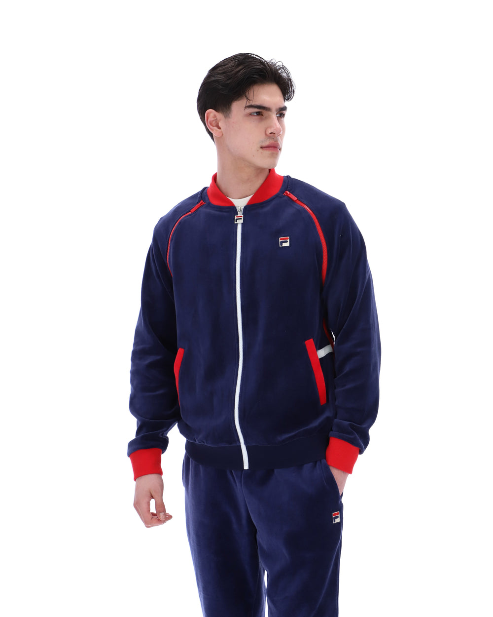 Person wearing a navy tracksuit with red accents on a white background