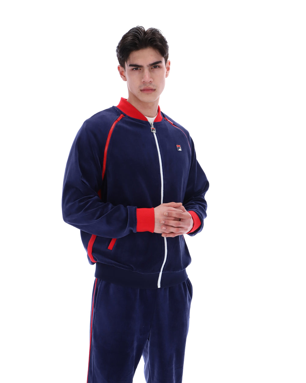 Person wearing a navy tracksuit with red accents on a white background