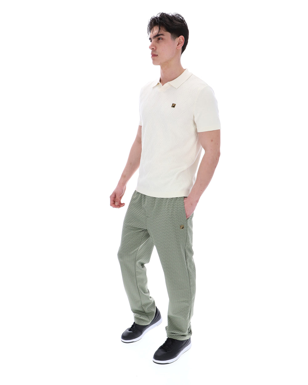 Man wearing a white polo shirt and green checkered pants on a white background