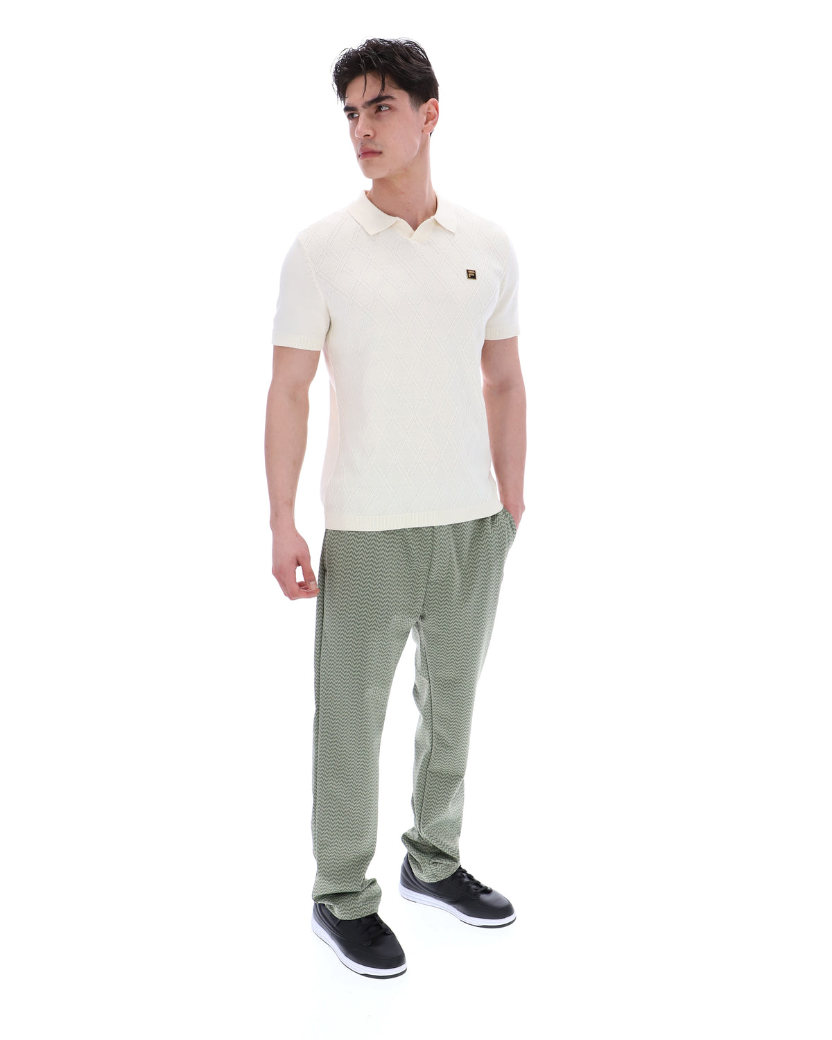 Man wearing a white polo shirt and green pants on a white background