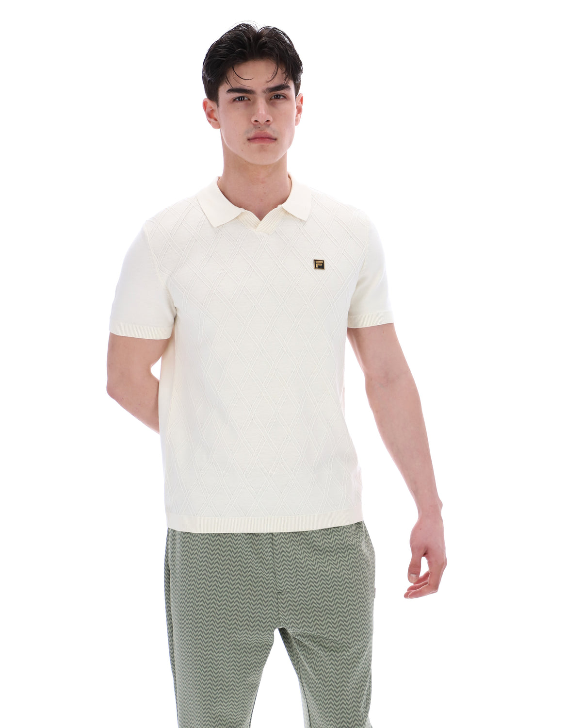 Man wearing a white polo shirt and green pants on a white background