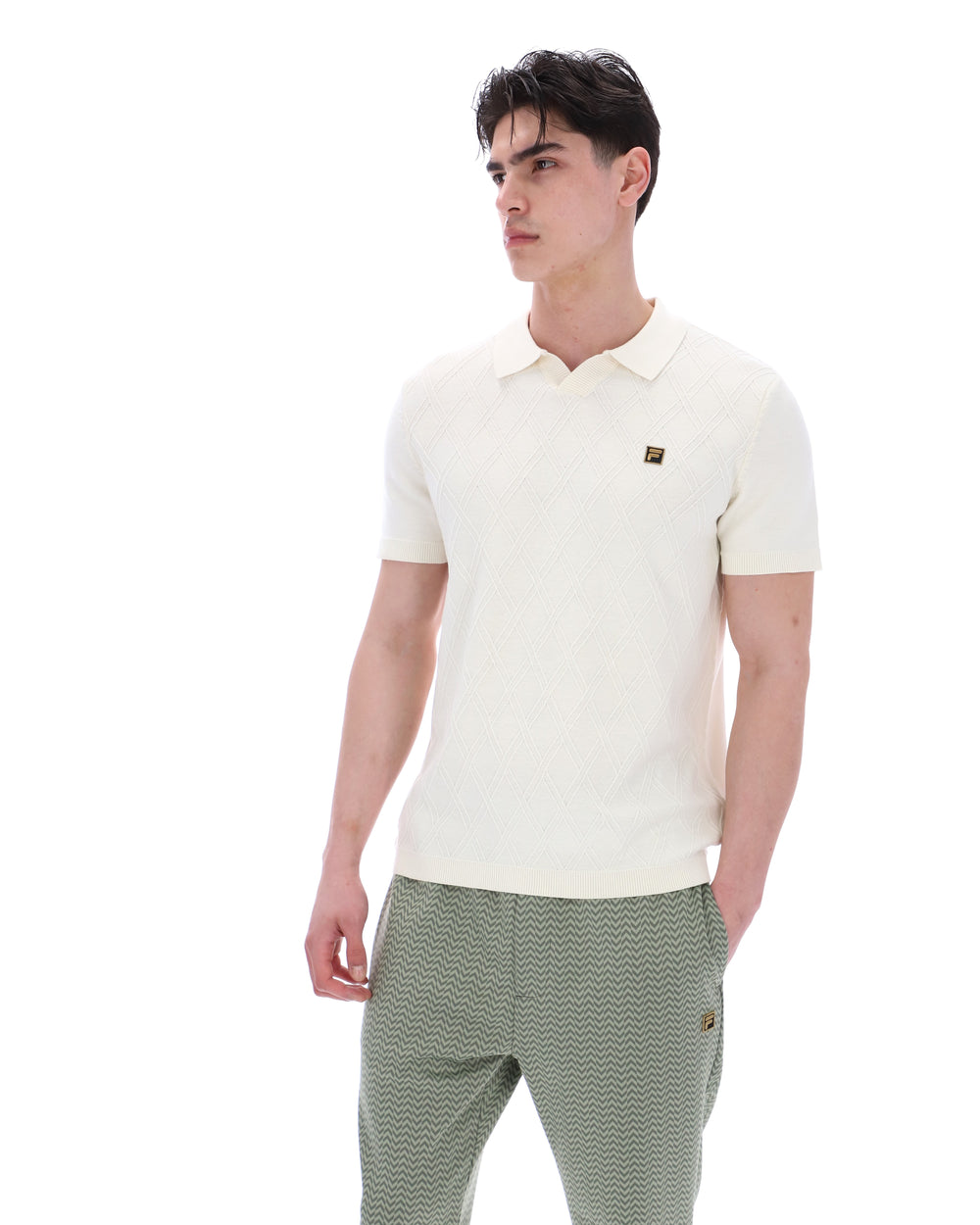 Man wearing a white polo shirt and green pants on a white background