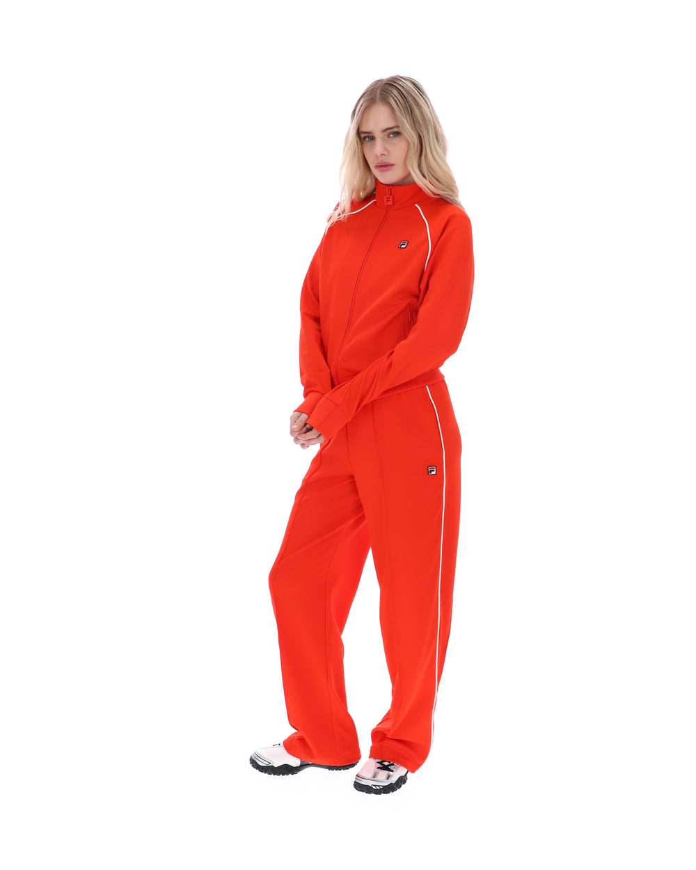 Person wearing a bright orange tracksuit on a white background
