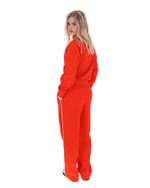 Person wearing a bright orange tracksuit on a white background