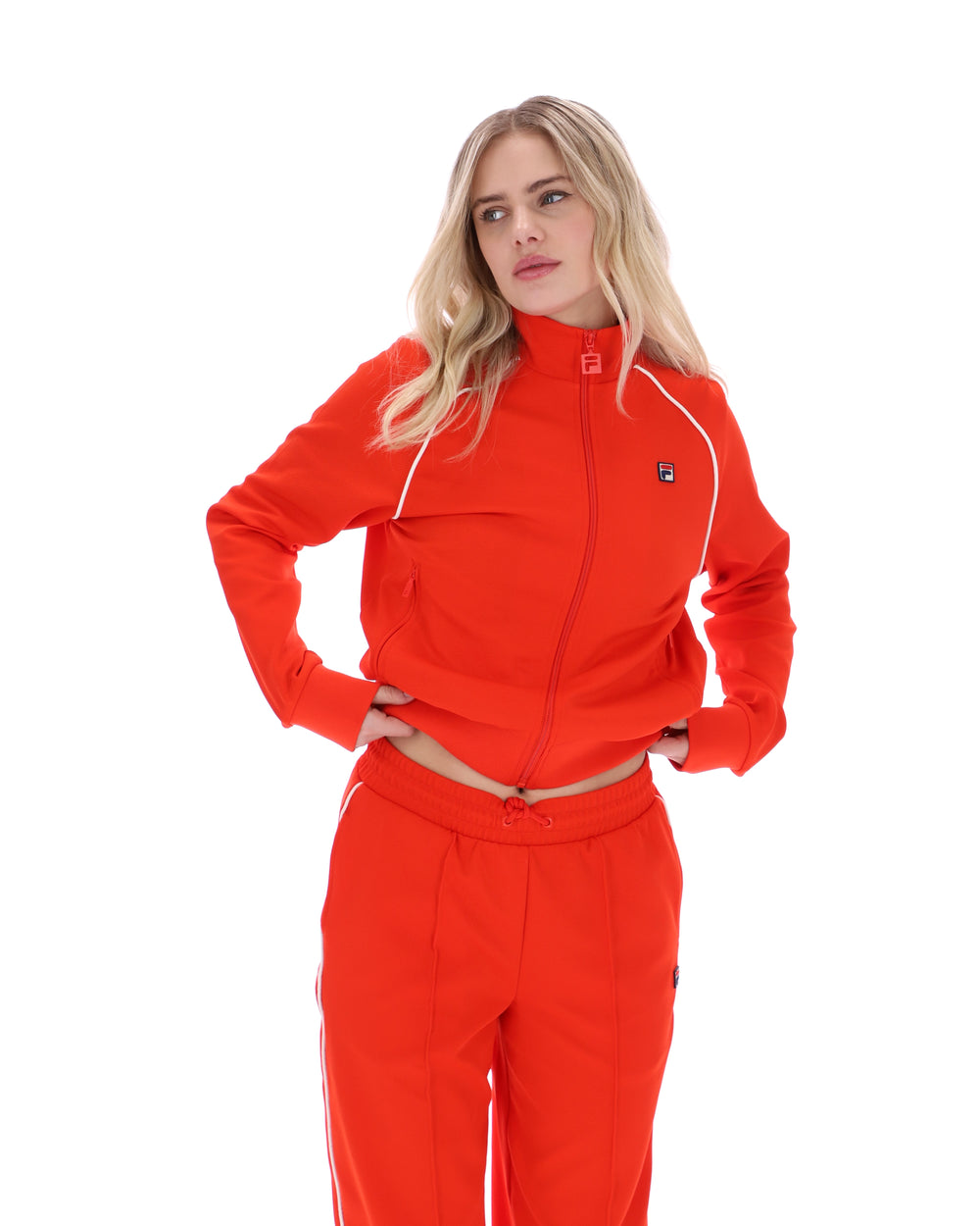 Woman wearing a bright orange tracksuit on a white background