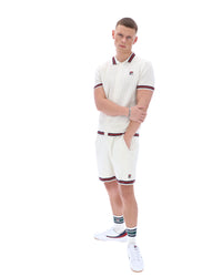 Person wearing a white tennis outfit with maroon accents on a white background