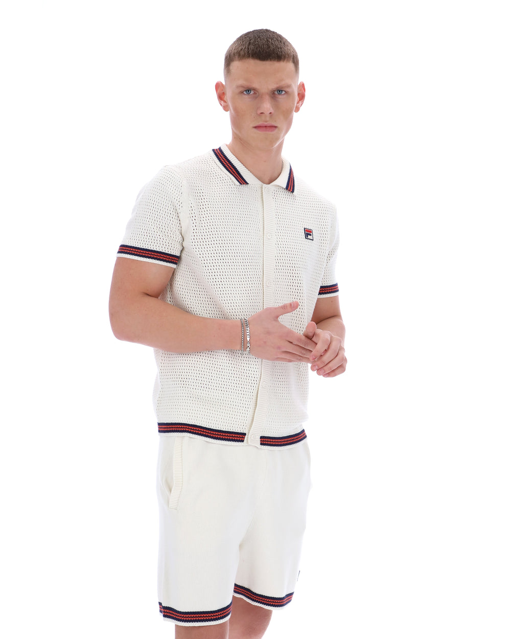 Man wearing a white textured shirt and shorts with red and blue trim on a white background