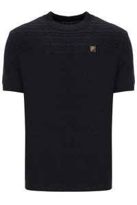 Black t-shirt with a small FILA Gold logo on the chest on a white background