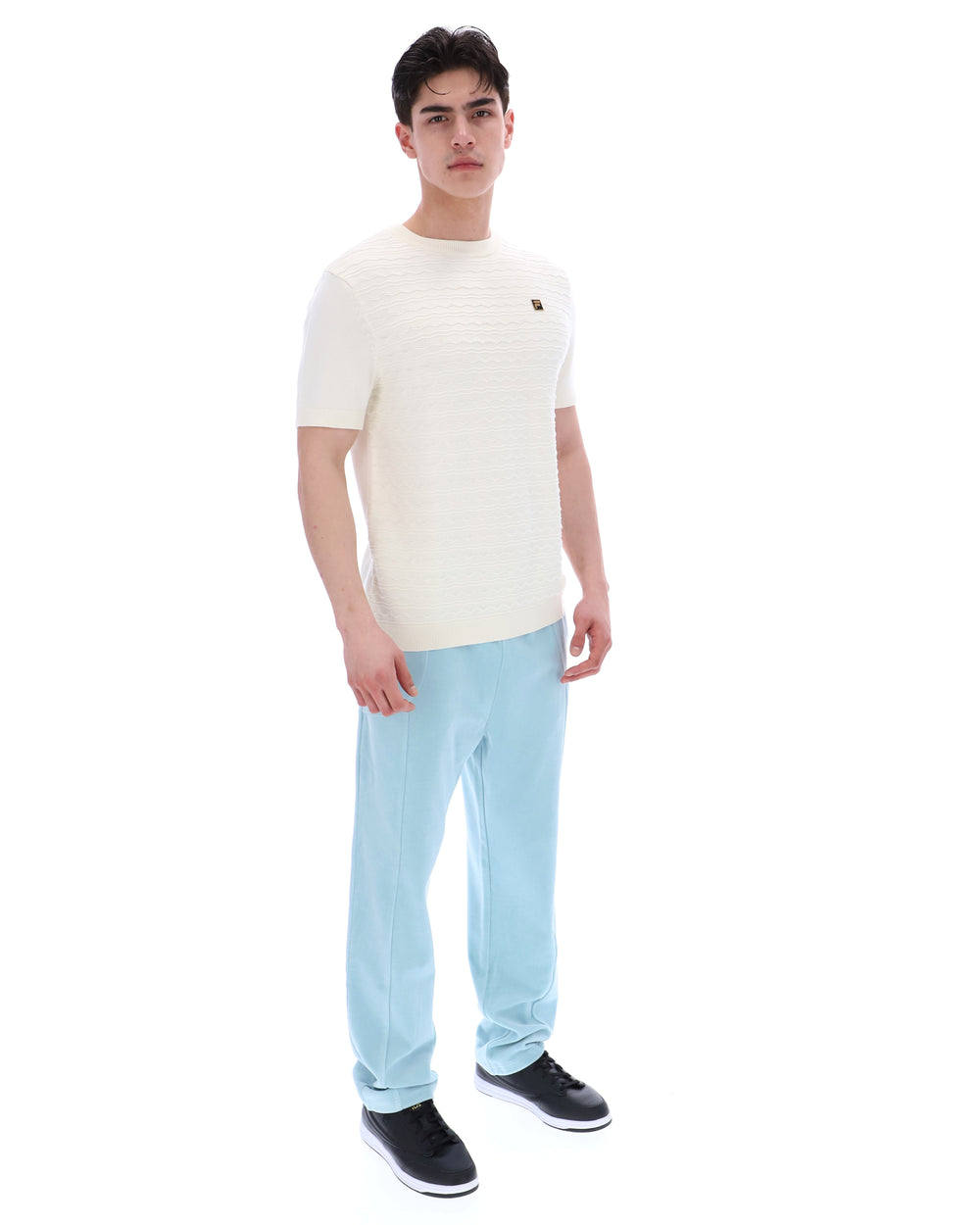 Man wearing a white t-shirt and light blue jeans on a white background