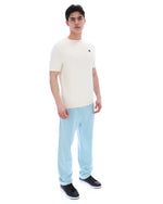 Man wearing a white t-shirt and light blue jeans on a white background