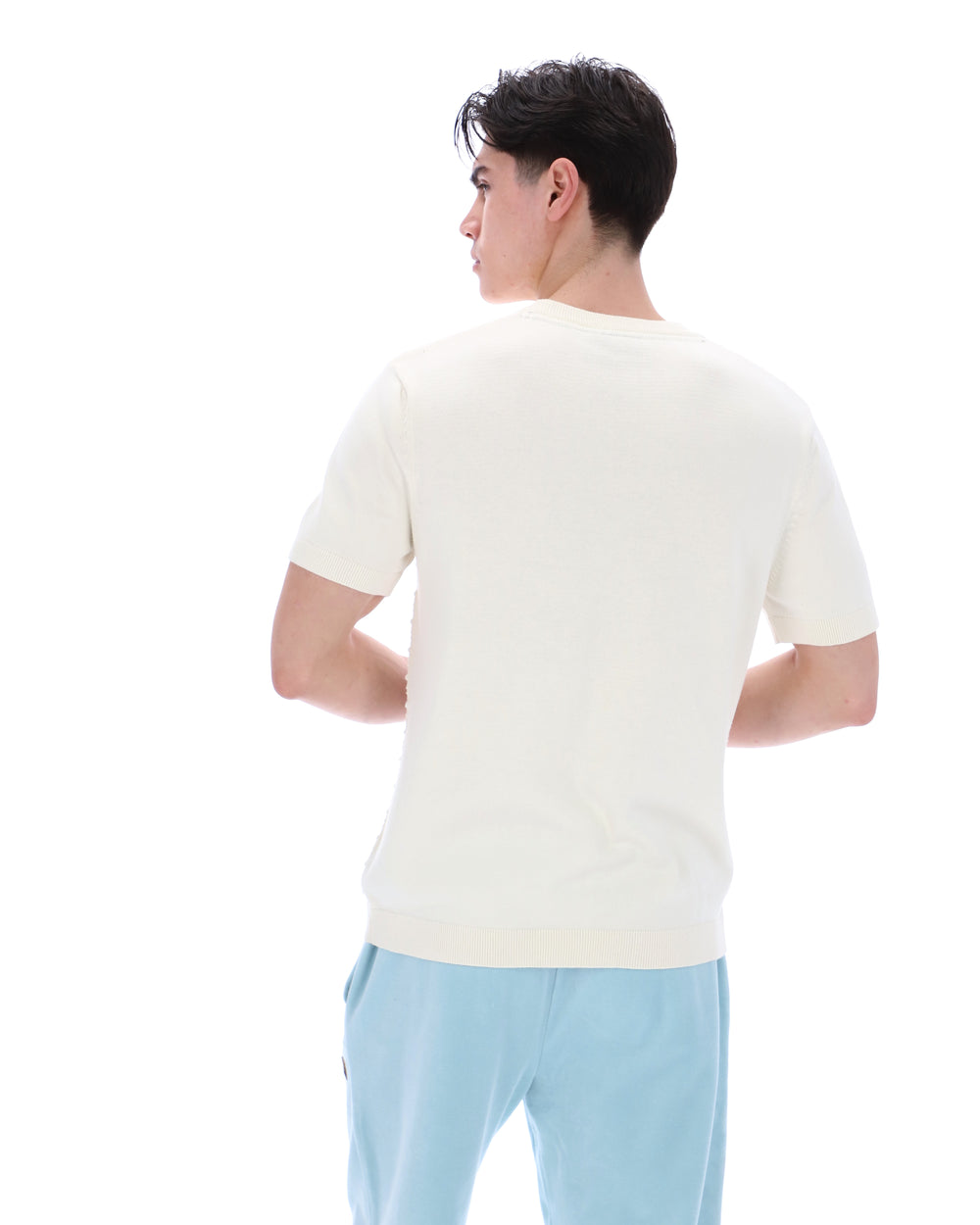 Man wearing a white t-shirt and light blue pants on a white background