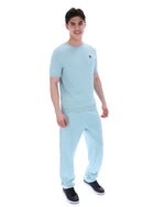 Man wearing a light blue textured t-shirt and pants on a white background