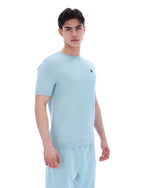 Man wearing a light blue textured t-shirt and pants on a white background