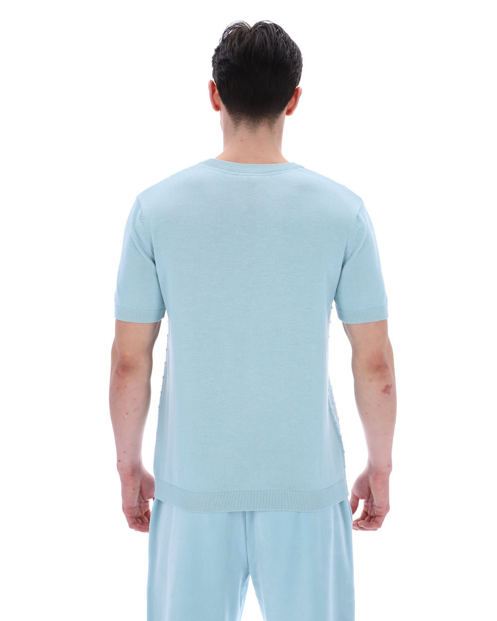 Person wearing a light blue t-shirt and pants on a white background
