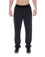 Black patterned jogger pants worn by a person on a white background