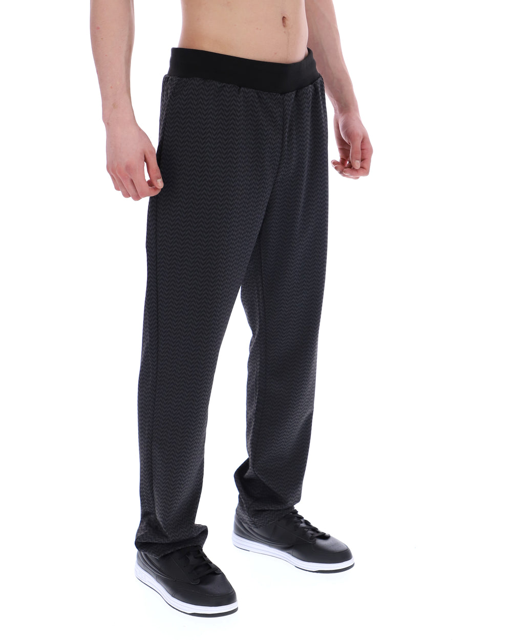 Person wearing black patterned pants on a white background