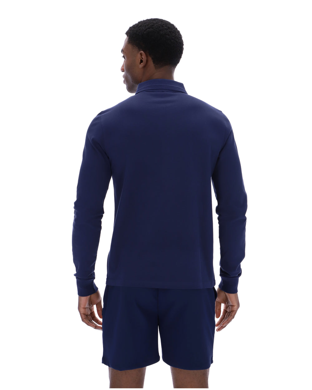 Man wearing a navy blue long-sleeve shirt and shorts on a white background