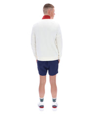 Person wearing a white sweater and blue shorts on a white background
