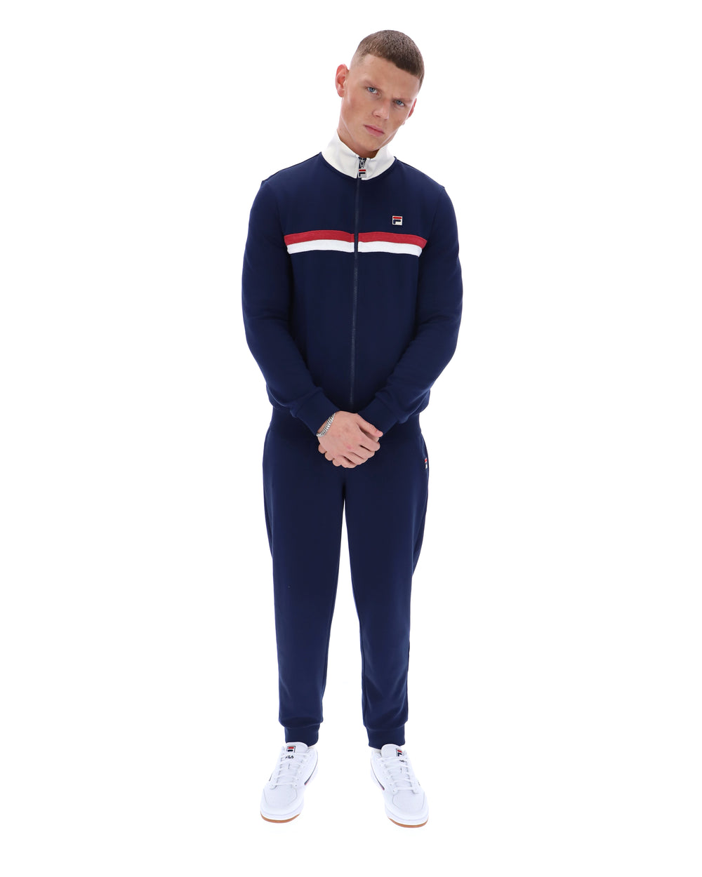 Man wearing a navy tracksuit with a brand logo on a white background