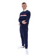 Man wearing a navy tracksuit with white and red accents on a white background