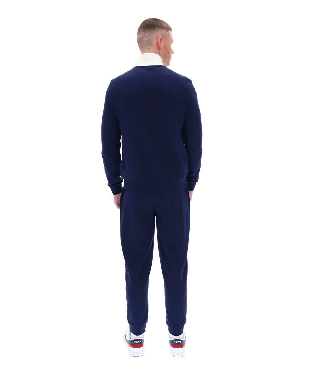 Man wearing a navy blue tracksuit on a white background