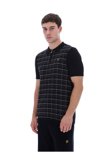 A man modeling a black short-sleeve polo shirt with a white windowpane plaid pattern on the front panel and a small gold logo on the chest, set against a plain white background.