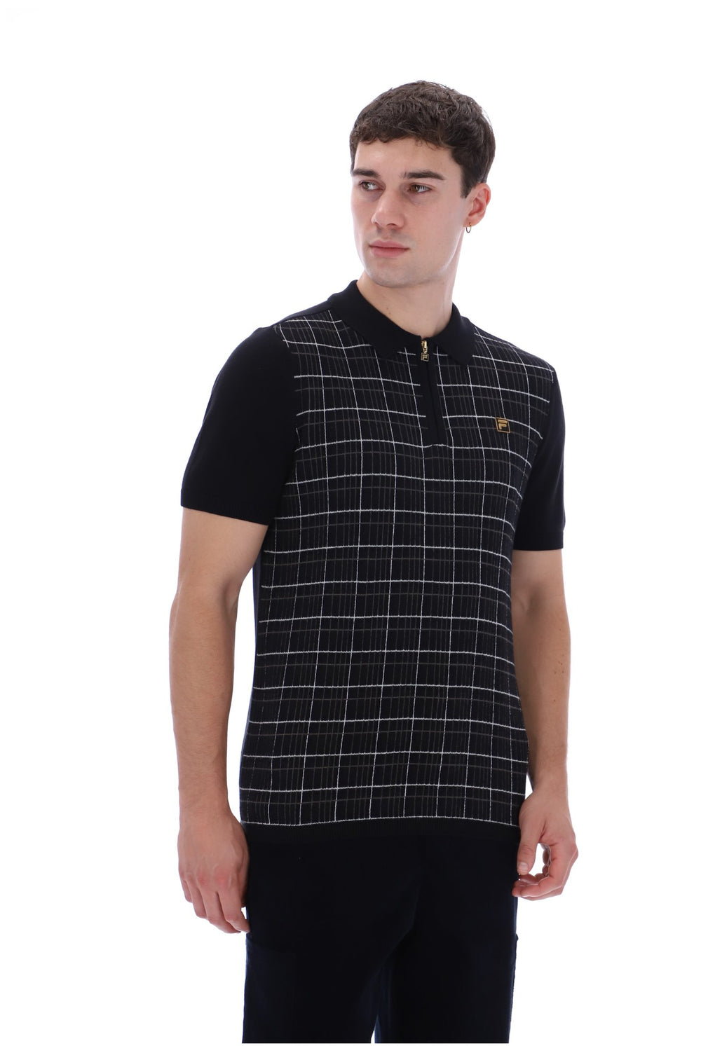 A man wearing a black short-sleeve polo shirt with a white windowpane plaid pattern on the front panel and a small gold embroidered logo on the chest, photographed against a plain white background.