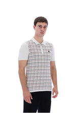 A man wearing a short-sleeve polo shirt with a white base, beige and brown plaid pattern on the front, and solid white sleeves, paired with black pants, against a plain white background.