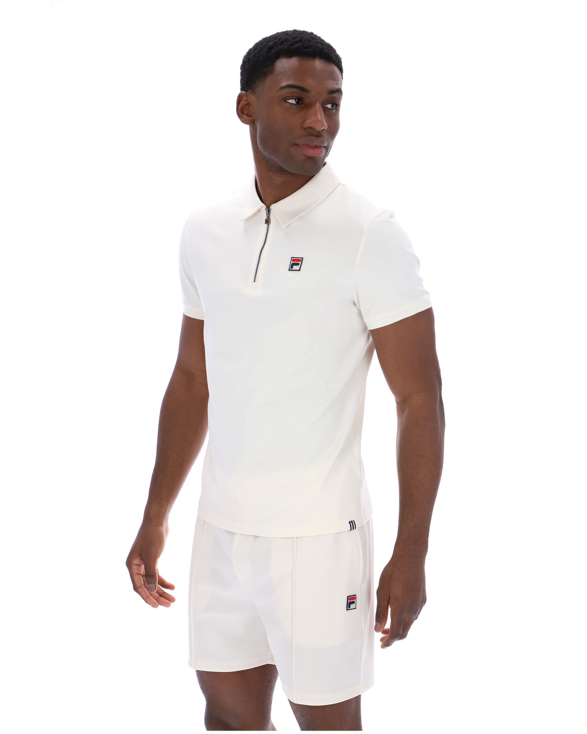 Displays a model wearing the Gardenia 'FILA' branded Ettore Zip Polo