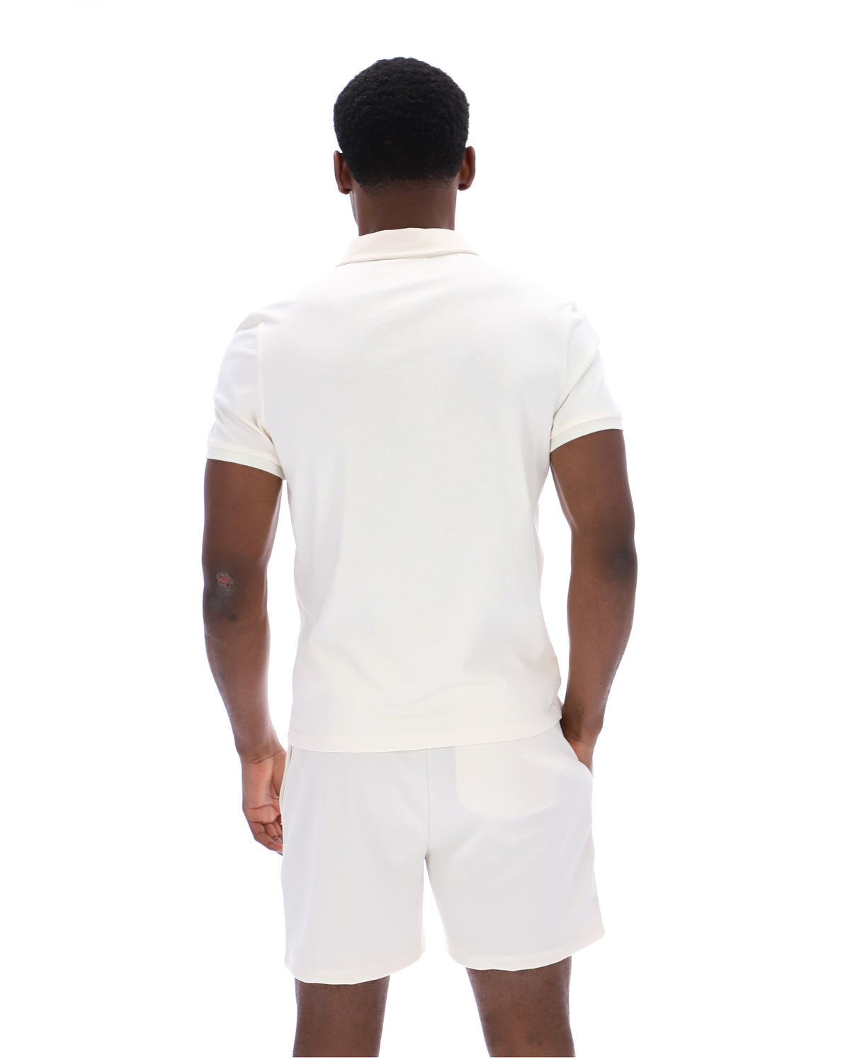 Displays a model wearing the Gardenia 'FILA' branded Ettore Zip Polo