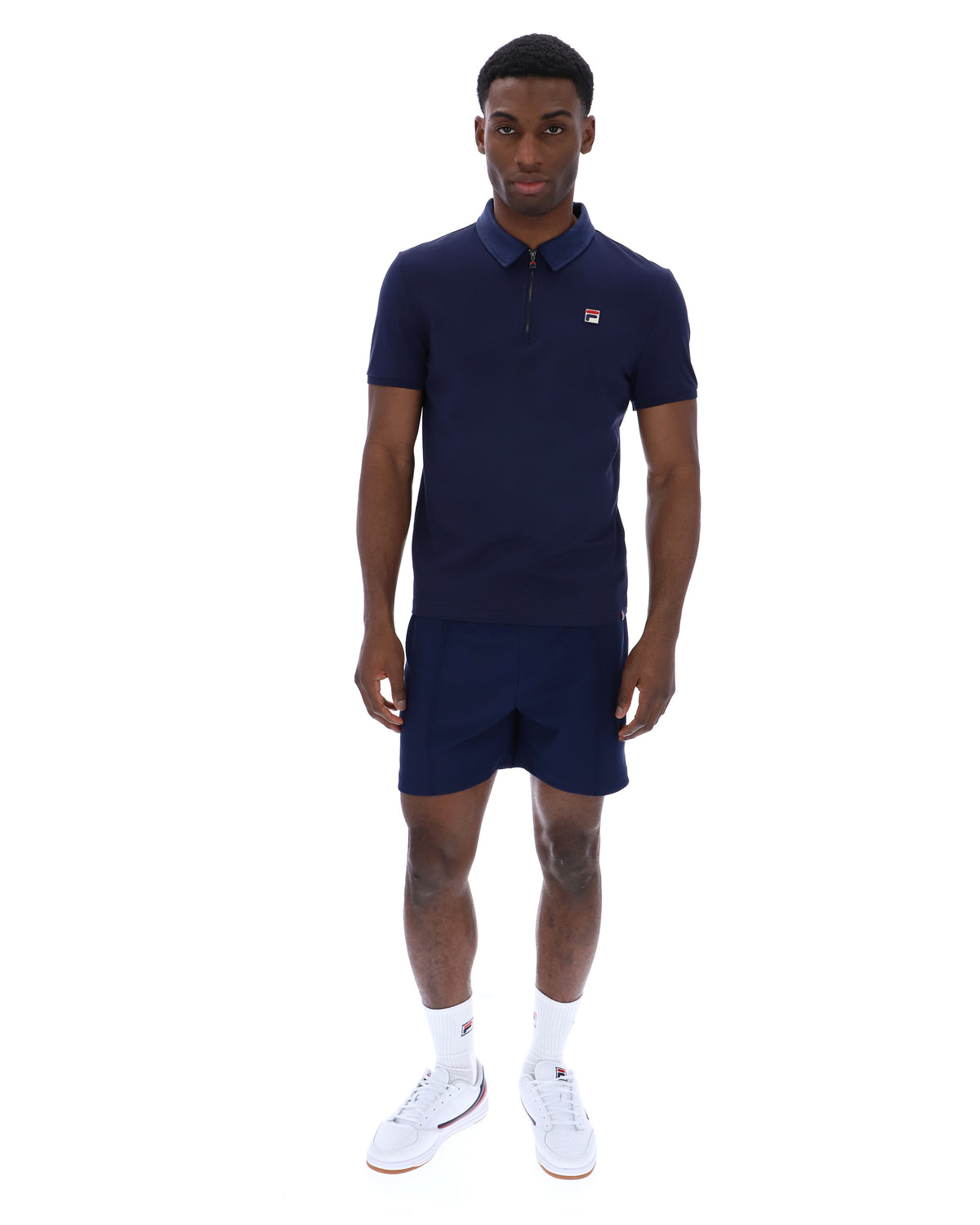 Displays a model wearing the Navy 'Fila' branded Ettore Zip Polo