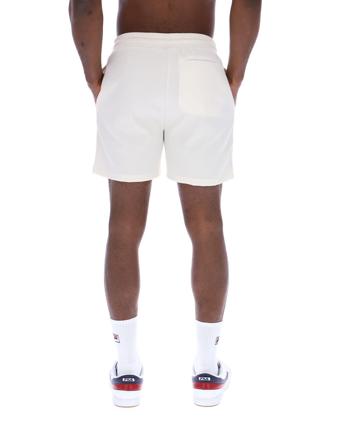 Displays a model wearing the Gardenia 'FILA' branded Eusebio Pin-Tuck Shorts