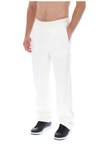 Displays a model wearing the White 'FILA' branded Down Fario Velour Track Pant