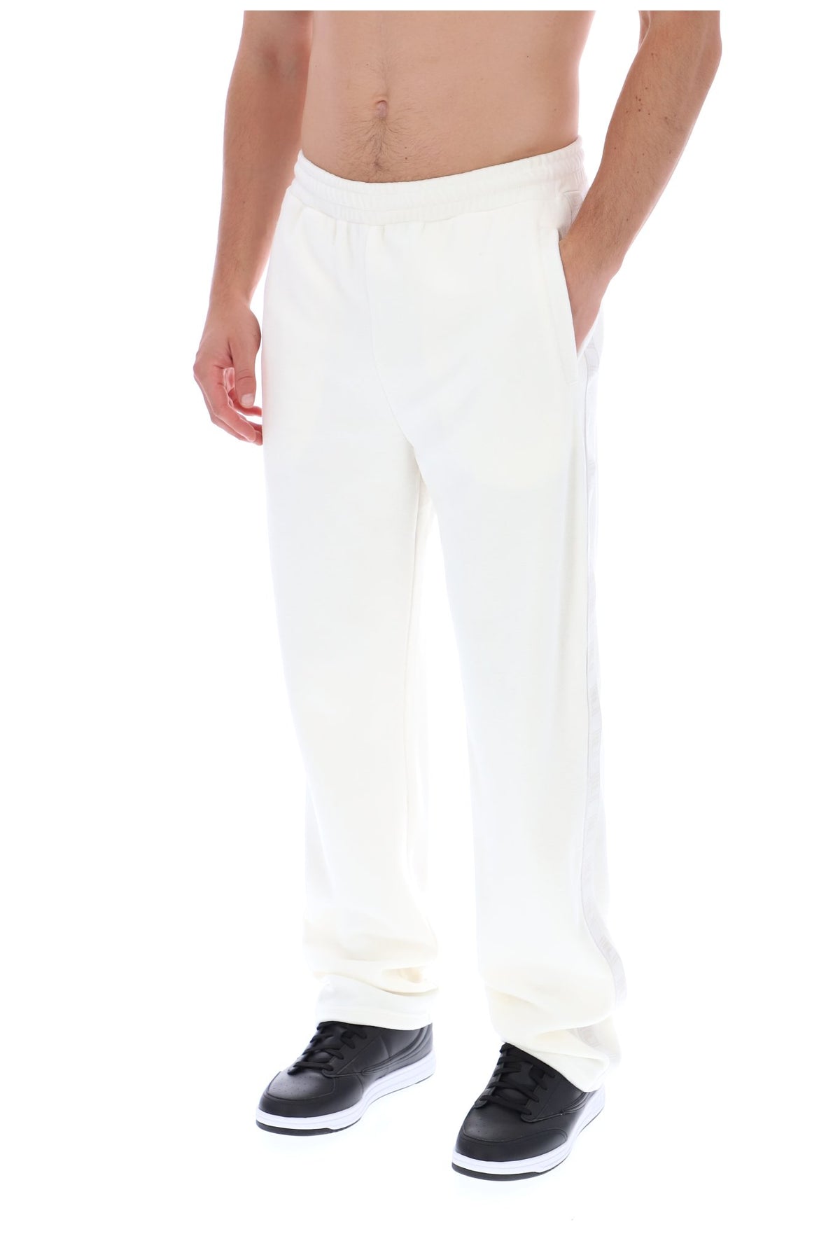 Displays a model wearing the White 'FILA' branded Down Fario Velour Track Pant