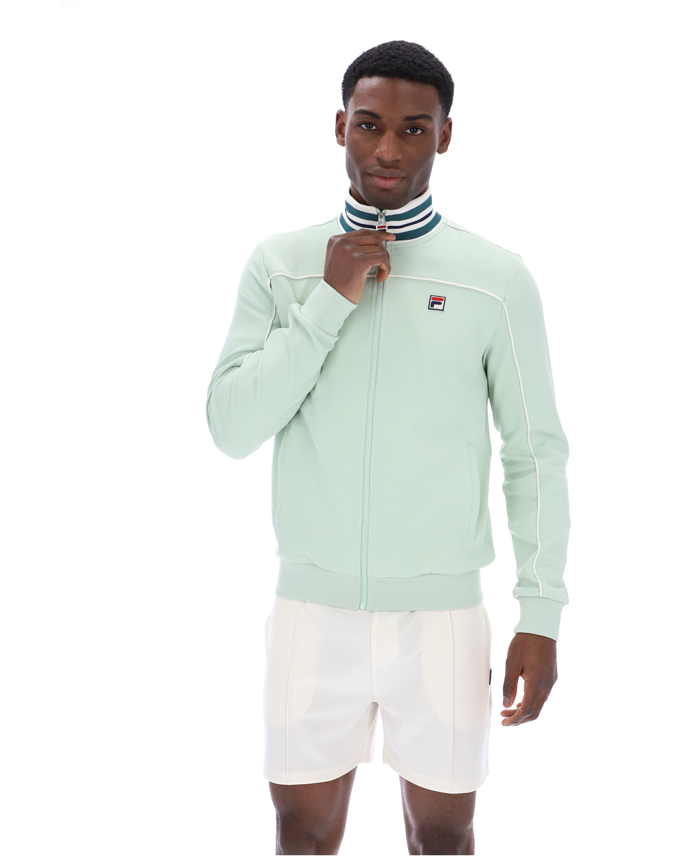 Man wearing a light green tracksuit jacket with a white background