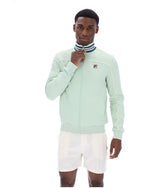 Man wearing a light green tracksuit jacket with a white background