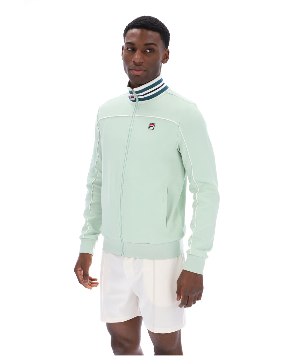 Man wearing a light green jacket with a FILA logo on a white background