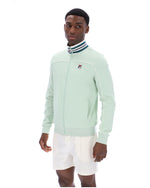 Man wearing a light green jacket with a FILA logo on a white background