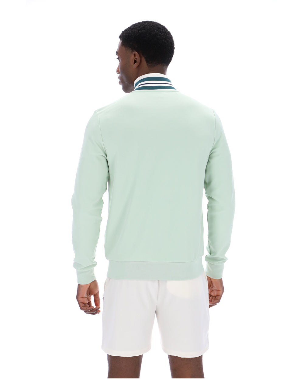 Man wearing a light green track jacket and white shorts on a white background