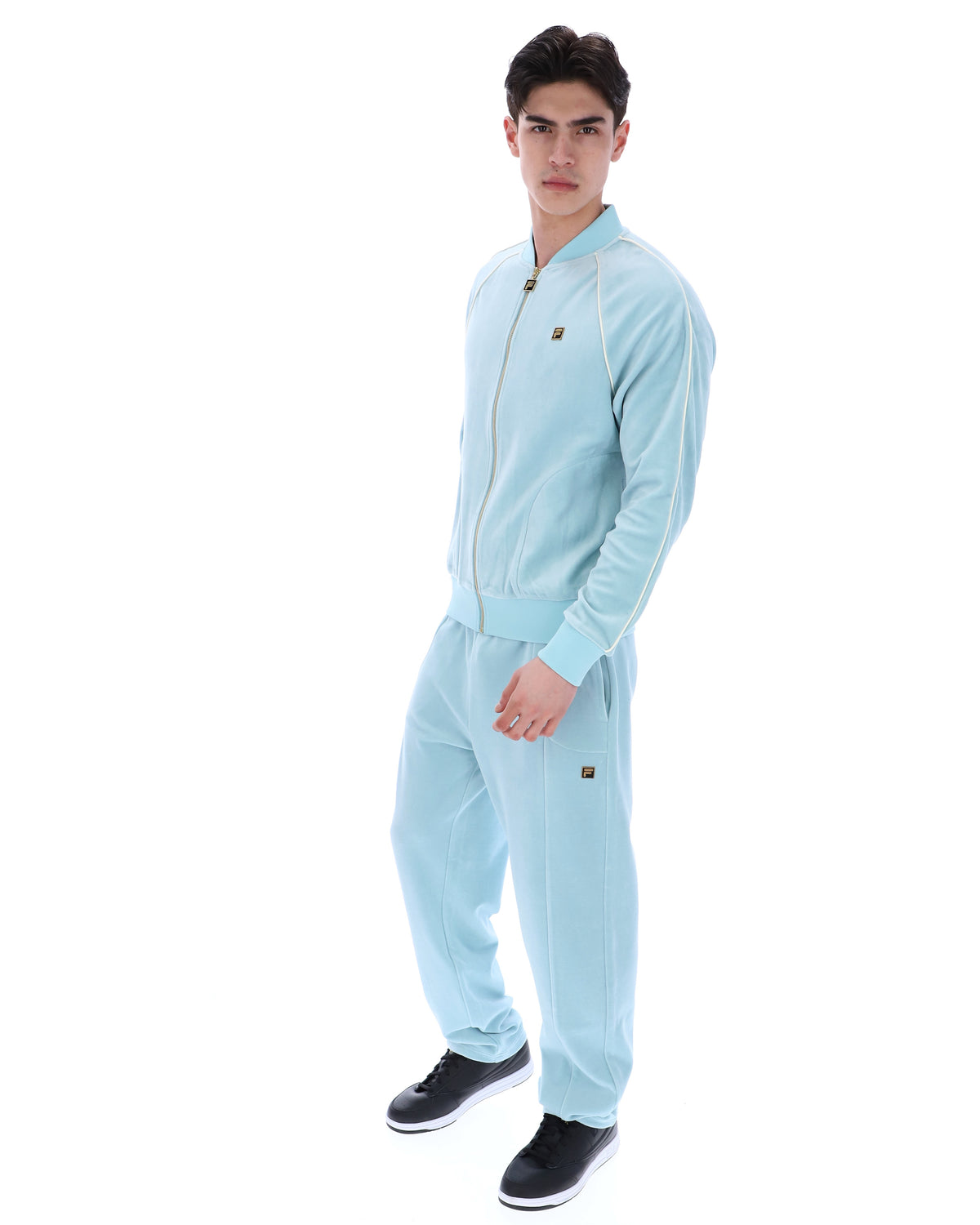 Man wearing a light blue onesie with buttons on a white background