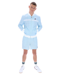 Man wearing a light blue tracksuit with white accents on a white background