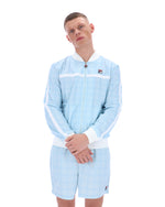 Person wearing a light blue tracksuit with white accents on a white background
