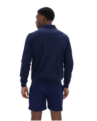 Person wearing a navy track jacket and shorts on a white background